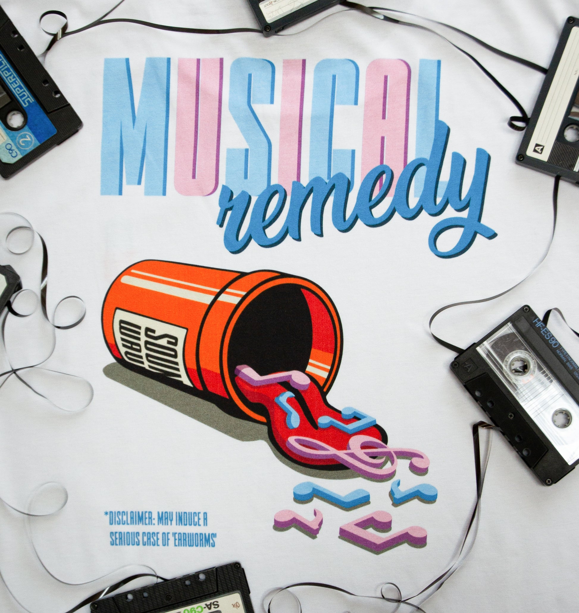Close-up of MUSICAL REMEDY design with a cartoon pill bottle and music note shaped pills surrounded by cassettes