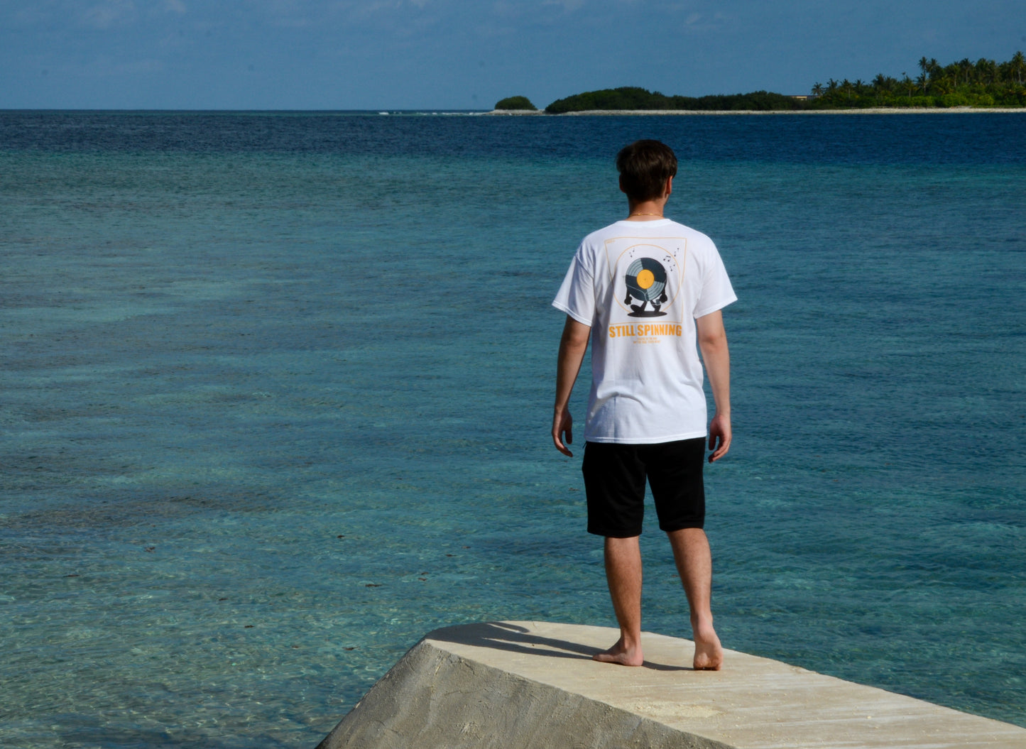Person wearing the STILL SPINNING T-shirt with vinyl music inspired design