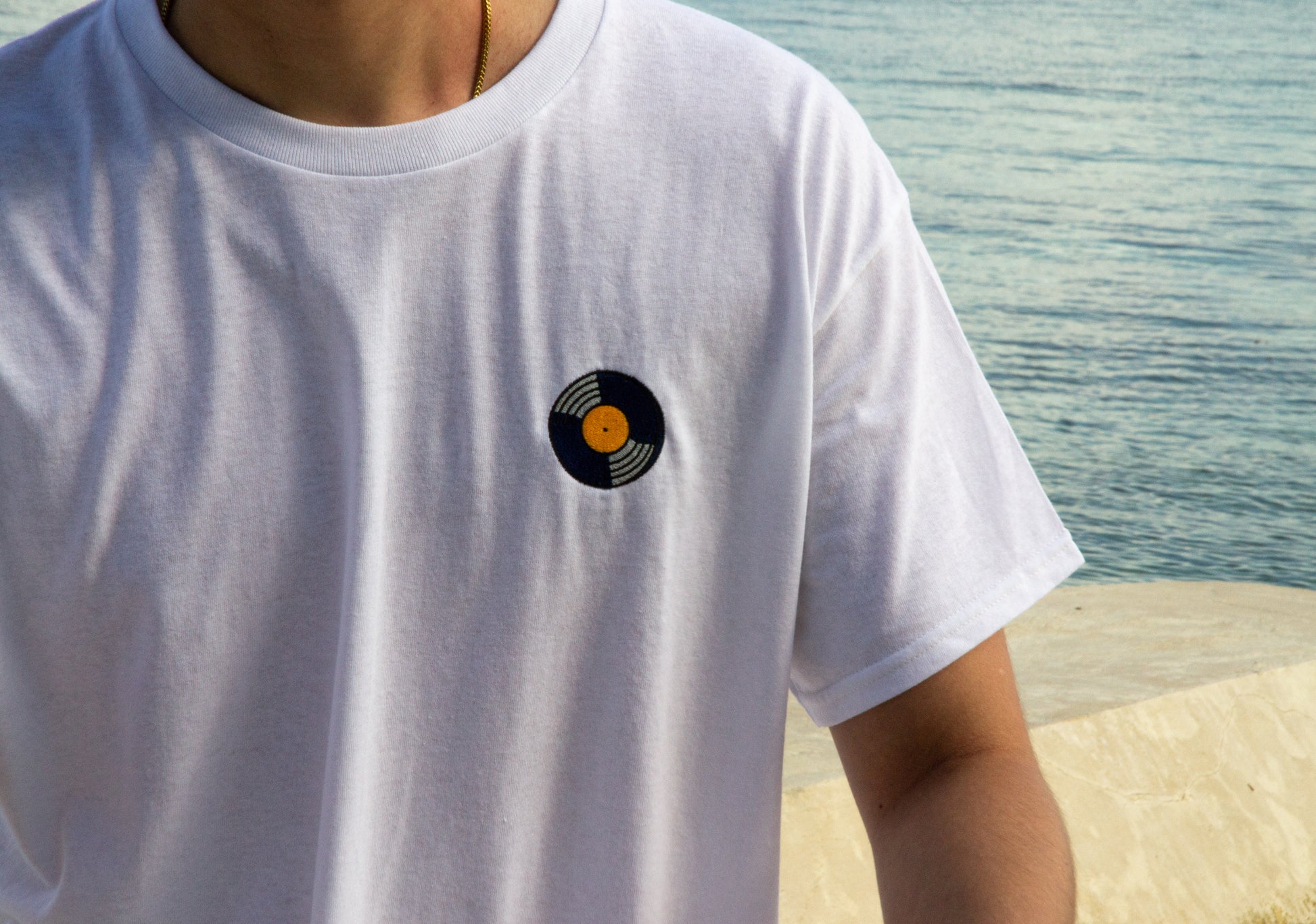 Person wearing the STILL SPINNING T-shirt with vinyl music inspired design